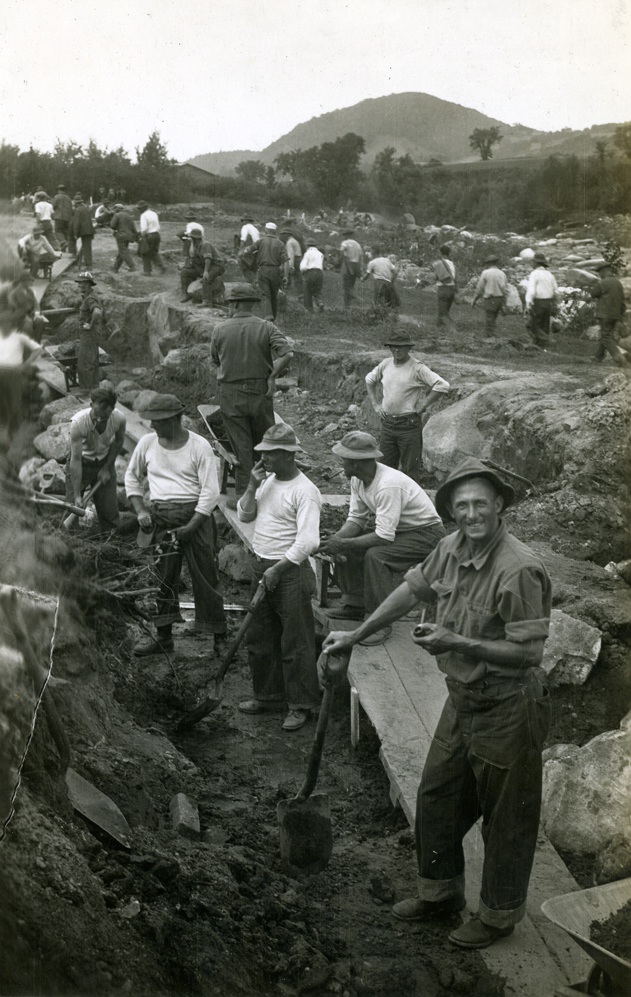 Men with shovels excavating soil and rocks